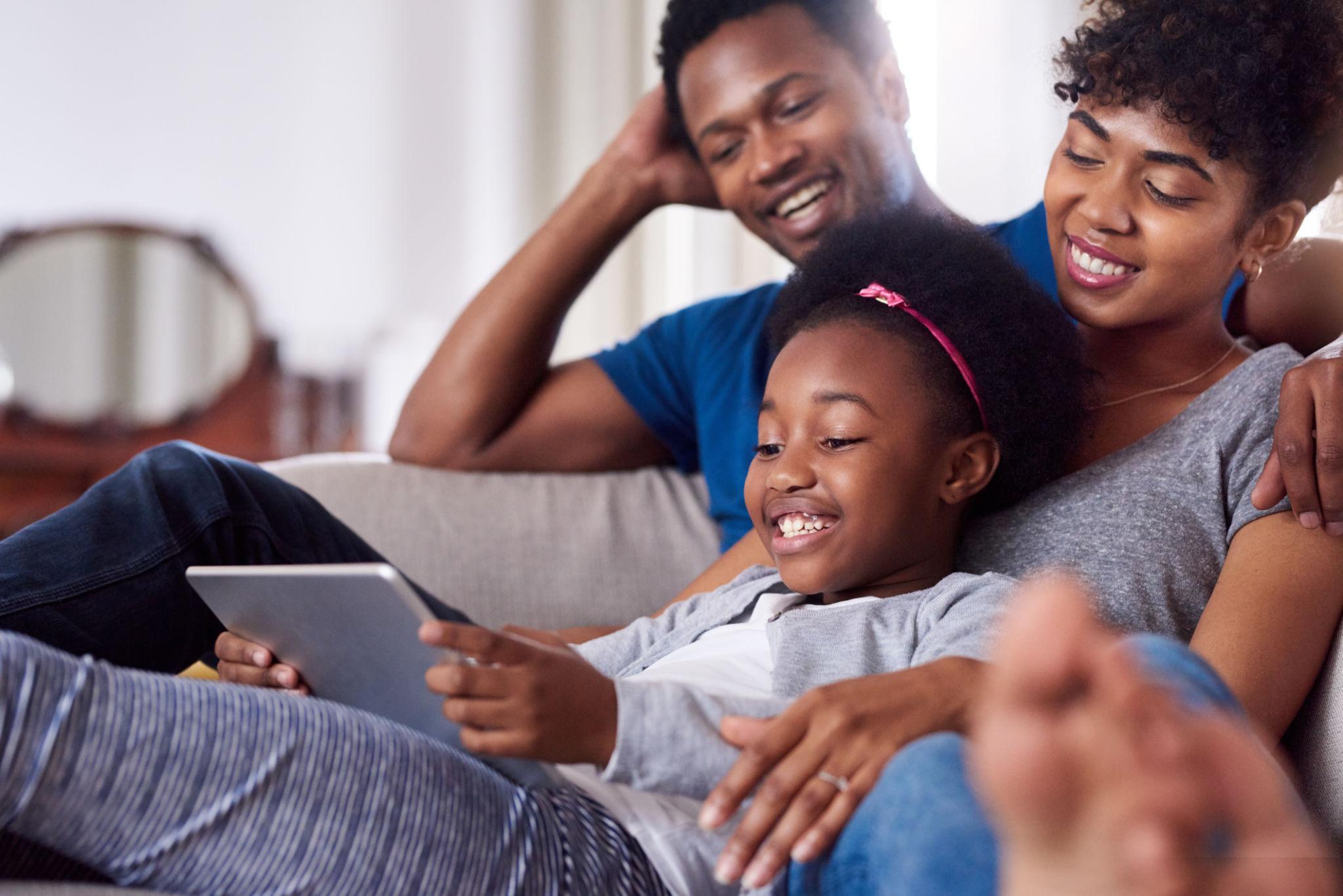 Family using a tablet together at home.